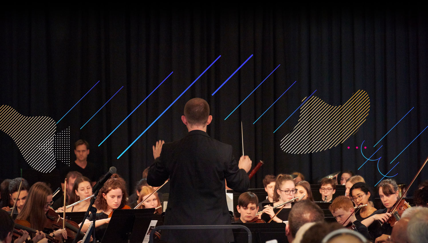 Conductor stood in front of youth orchestra